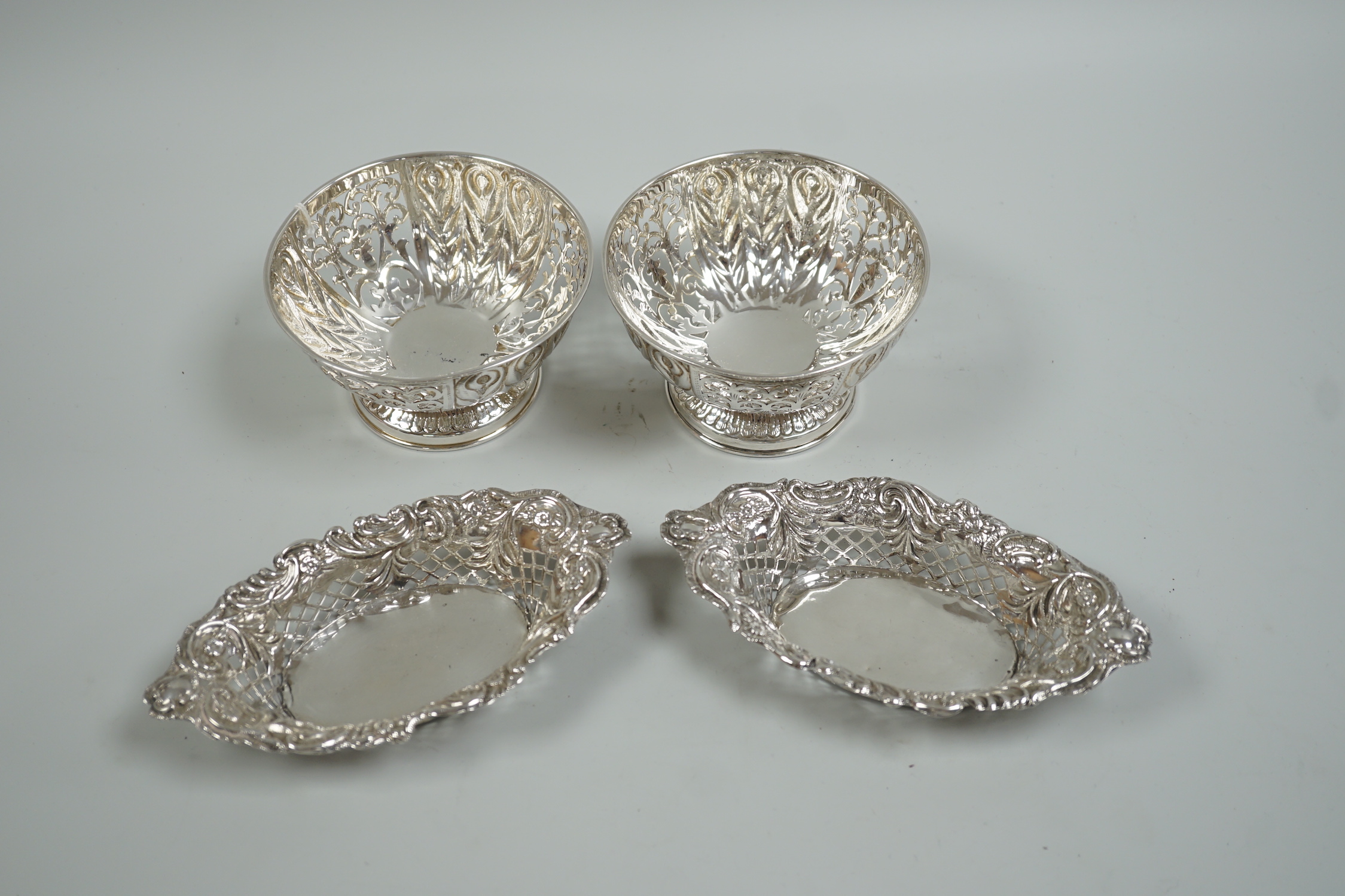 A modern pair of pierced silver circular bowls, by C.J. Vander Ltd, diameter 10.8cm and a pair of late Victorian silver bonbon dishes, 10oz.